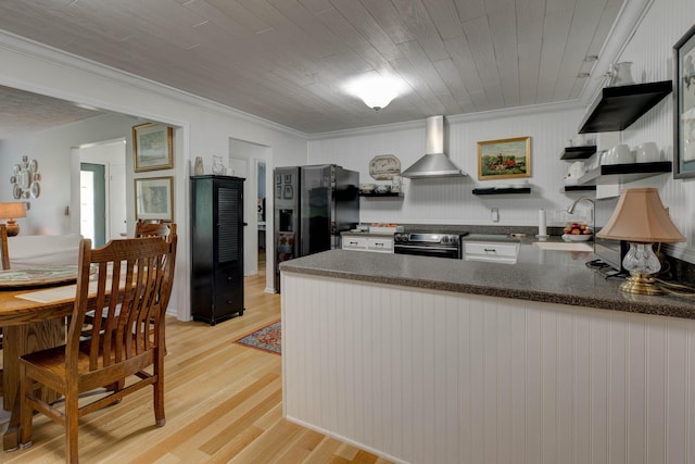 kitchen with wall chimney range hood, a sink, a peninsula, electric stove, and light wood-style floors