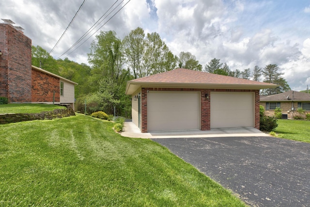 view of property exterior with a detached garage, an outdoor structure, a lawn, and brick siding