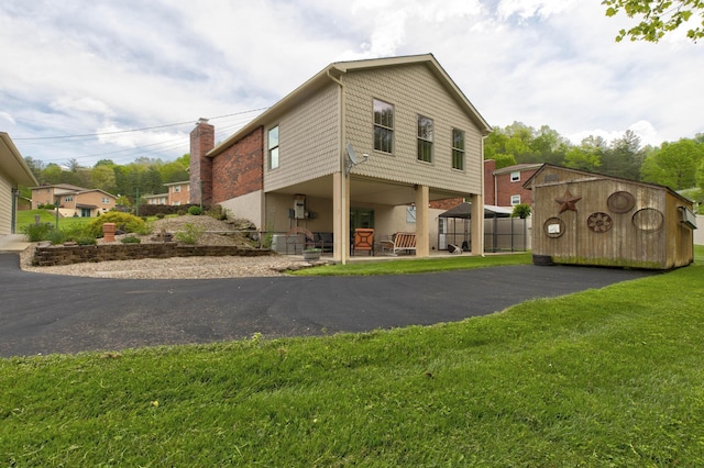 back of property featuring a lawn and a chimney