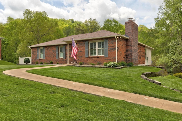 ranch-style house featuring brick siding, a front lawn, and a chimney