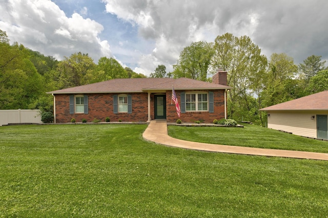 ranch-style house with fence, a chimney, a front lawn, and brick siding