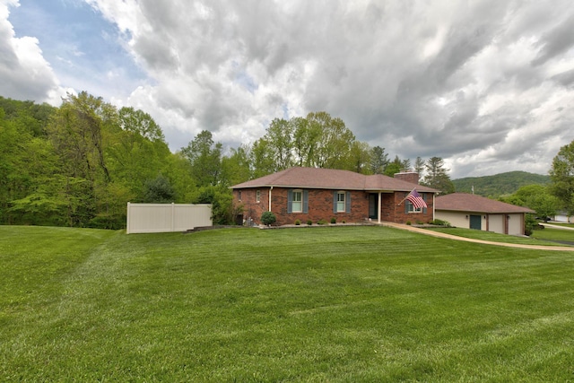 view of front facade featuring a detached garage, brick siding, a chimney, and a front lawn