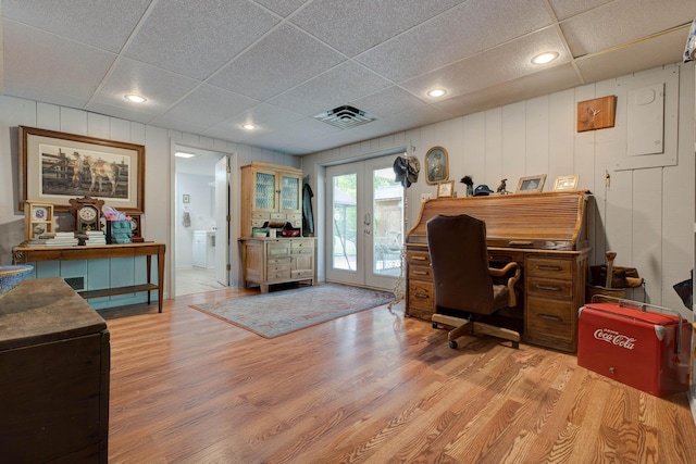 home office with visible vents, french doors, light wood finished floors, and a decorative wall
