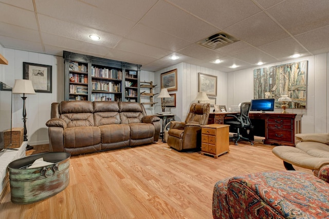 living area with visible vents, a drop ceiling, and light wood-style flooring