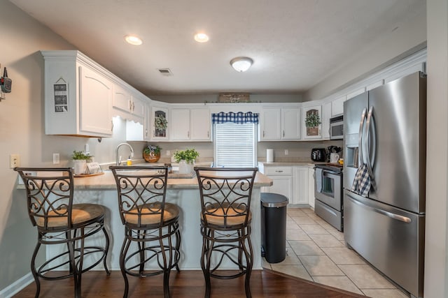 605 Coleman Dr, Berea, KY 40403 - kitchen with a peninsula, light countertops, white cabinets, and appliances with stainless steel finishes