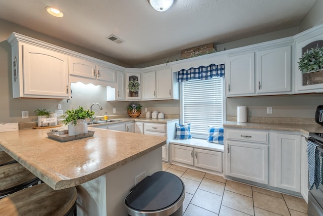 605 Coleman Dr, Berea, KY 40403 - kitchen featuring a peninsula, a breakfast bar area, visible vents, and white cabinetry