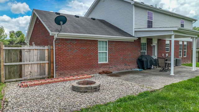 605 Coleman Dr, Berea, KY 40403 - rear view of house featuring brick siding, a fire pit, fence, a patio, and roof with shingles
