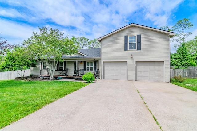 view of front of property with a porch, an attached garage, fence, and a front lawn