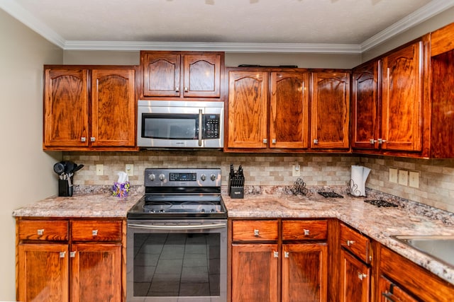 kitchen featuring stainless steel appliances, light stone countertops, decorative backsplash, and ornamental molding