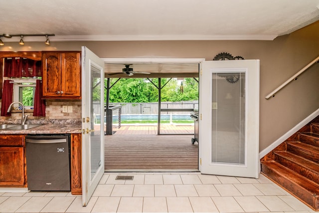 kitchen featuring stainless steel dishwasher, crown molding, ceiling fan, a sink, and backsplash