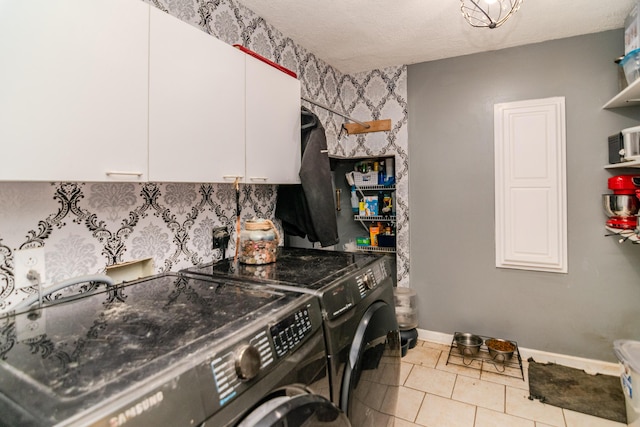 washroom with cabinet space, independent washer and dryer, baseboards, and tile patterned floors