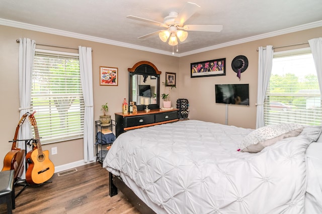 bedroom featuring ceiling fan, baseboards, ornamental molding, and wood finished floors