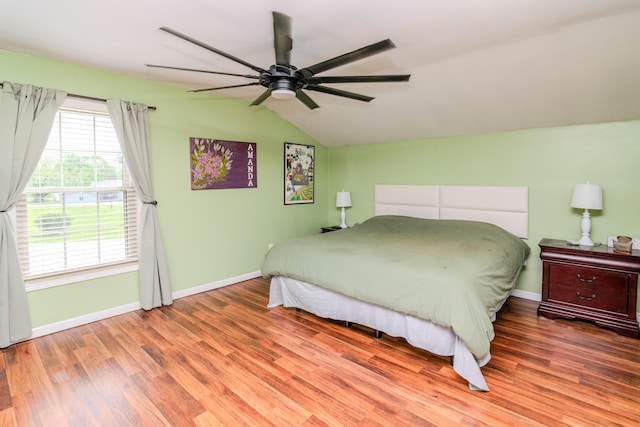bedroom featuring a ceiling fan, baseboards, wood finished floors, and lofted ceiling