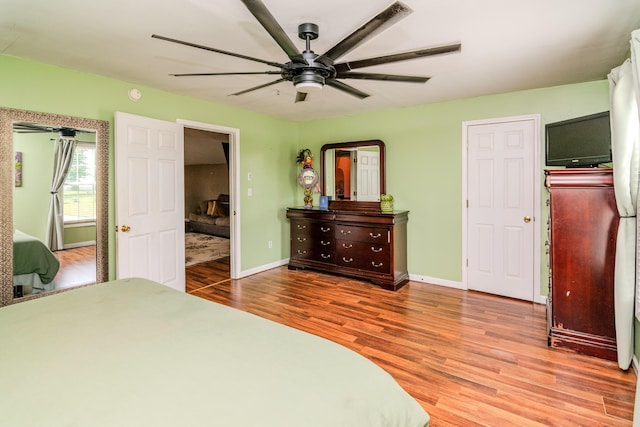 bedroom with baseboards, ceiling fan, and wood finished floors