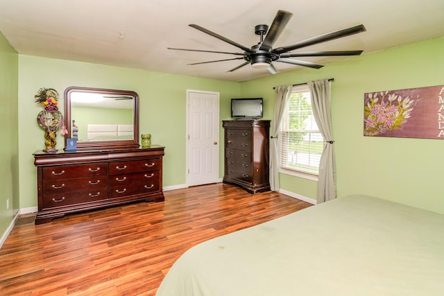 bedroom with baseboards, ceiling fan, and wood finished floors