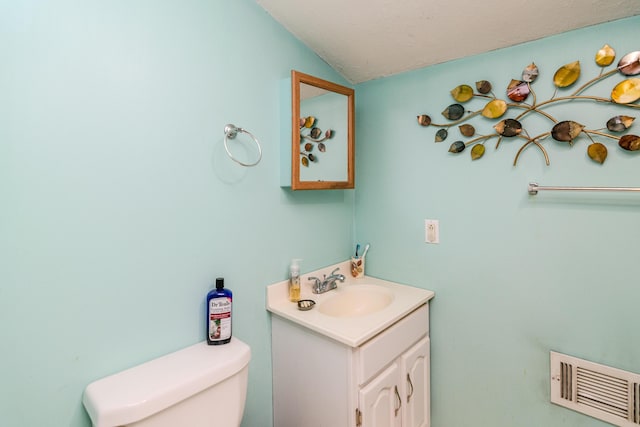 bathroom with toilet, visible vents, lofted ceiling, and vanity