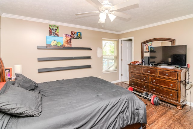 bedroom featuring a textured ceiling, baseboards, ornamental molding, and wood finished floors