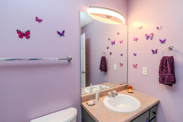 half bathroom with vanity and toilet