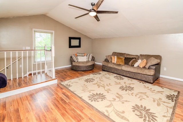 living area with baseboards, ceiling fan, vaulted ceiling, and wood finished floors