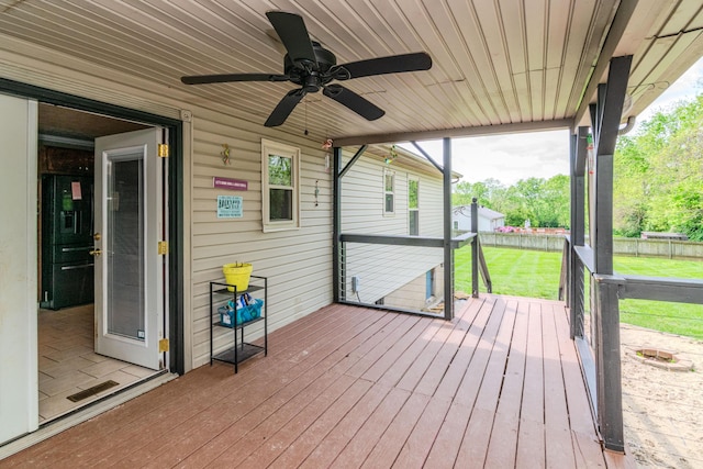 wooden terrace with a lawn, ceiling fan, and fence