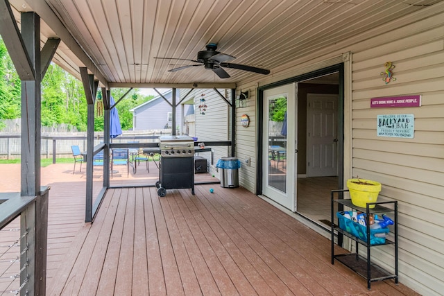 wooden terrace featuring fence, a ceiling fan, and a grill