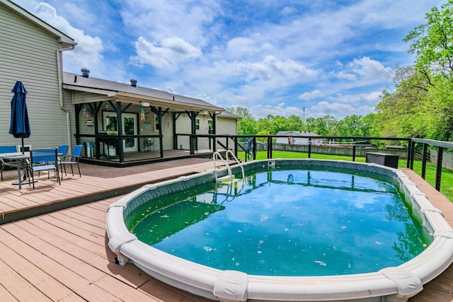 pool featuring a deck and a fenced backyard