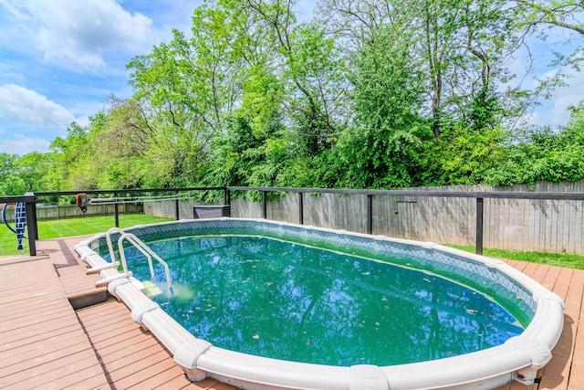 view of swimming pool featuring a fenced in pool, a fenced backyard, a yard, and a deck
