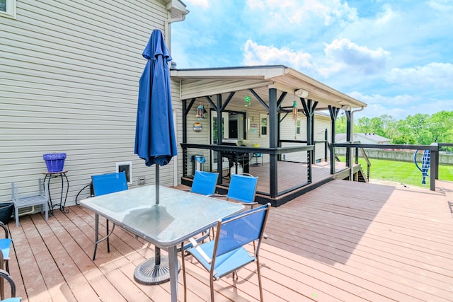 wooden terrace featuring a yard and outdoor dining area