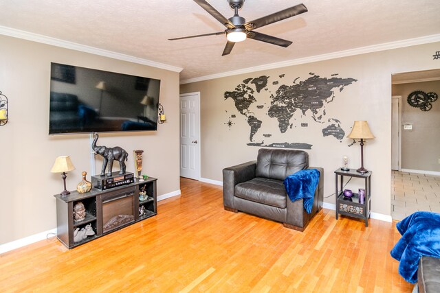 interior space featuring baseboards, ornamental molding, ceiling fan, and wood finished floors