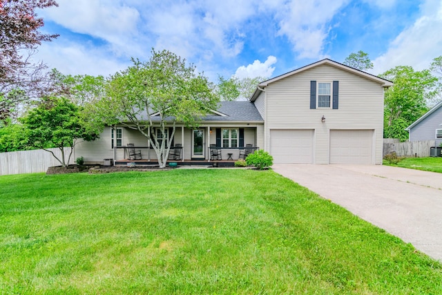 split level home featuring covered porch, driveway, fence, a front lawn, and an attached garage