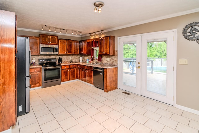 kitchen featuring appliances with stainless steel finishes, a sink, decorative backsplash, visible vents, and ornamental molding