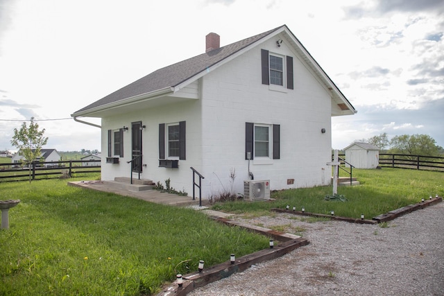 view of side of property featuring a shingled roof, fence, a yard, and a chimney