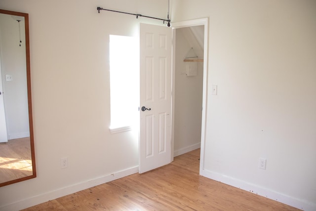 empty room featuring baseboards and light wood-style flooring