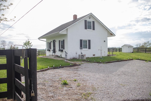 exterior space with fence, an outdoor structure, a chimney, and a yard