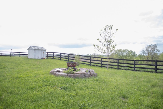 view of yard featuring a storage shed, fence, and an outdoor structure
