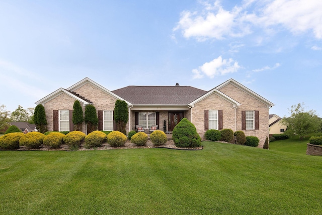 view of front of house featuring brick siding and a front yard