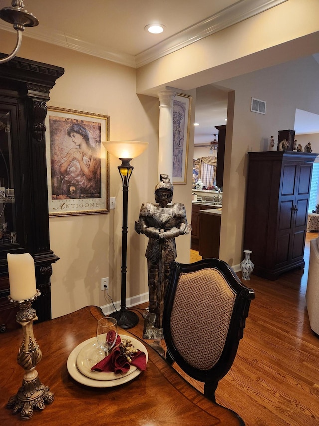 living area with decorative columns, wood finished floors, ornamental molding, baseboards, and recessed lighting
