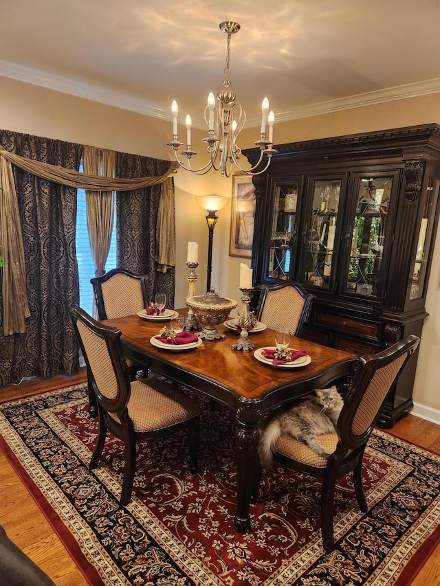dining room featuring a chandelier, crown molding, and wood finished floors