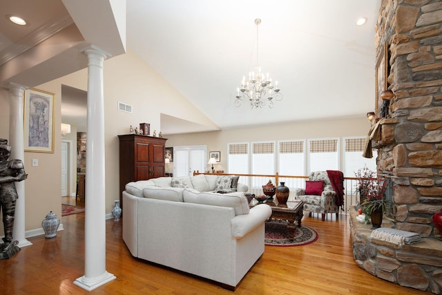 living room with decorative columns, light wood-style flooring, high vaulted ceiling, a chandelier, and baseboards