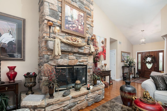 living room featuring wood finished floors, a fireplace, and high vaulted ceiling