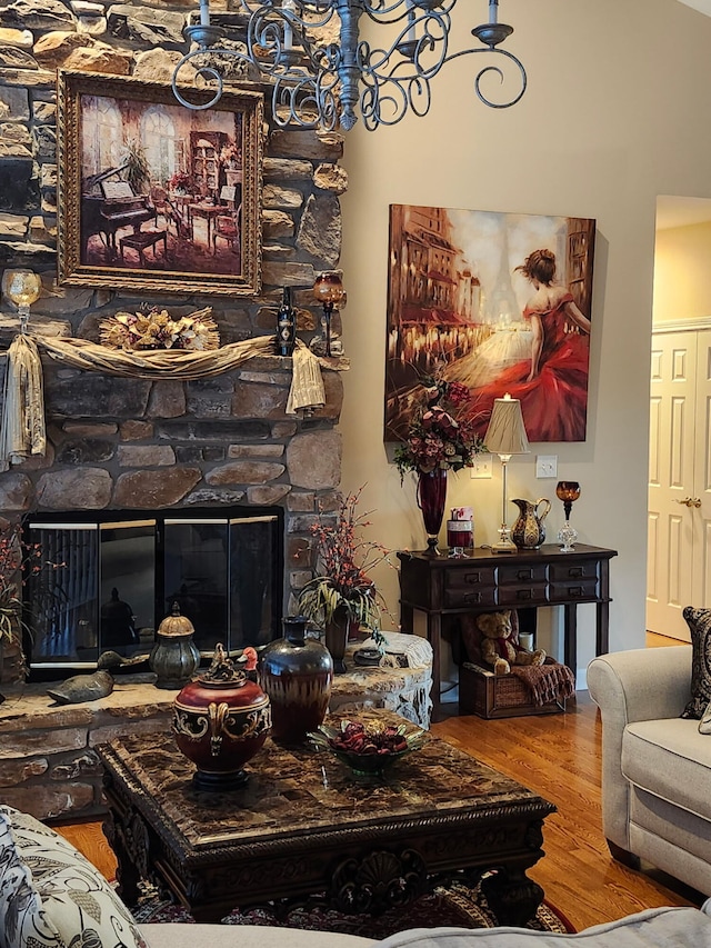 living area featuring wood finished floors, a chandelier, and a fireplace