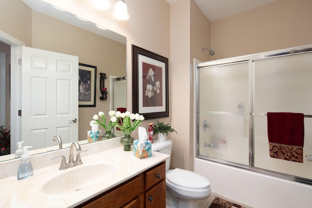 bathroom featuring vanity, combined bath / shower with glass door, toilet, and tile patterned flooring