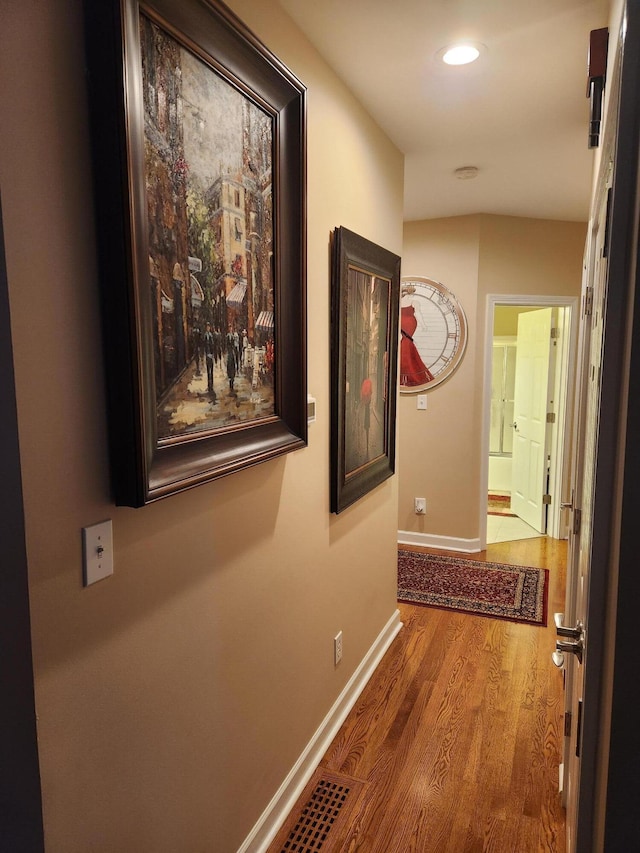 corridor featuring wood finished floors, recessed lighting, and baseboards