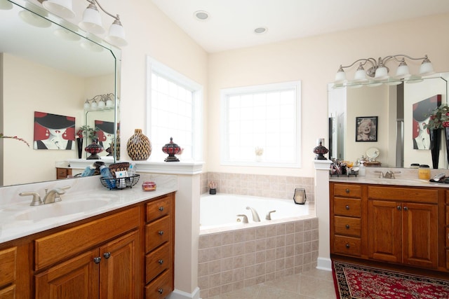 bathroom featuring tile patterned flooring, a bath, and two vanities