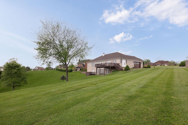 view of green lawn with a deck, a garage, and stairway