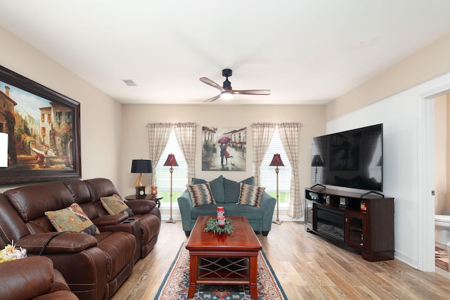 living room featuring wood finished floors, a ceiling fan, and baseboards