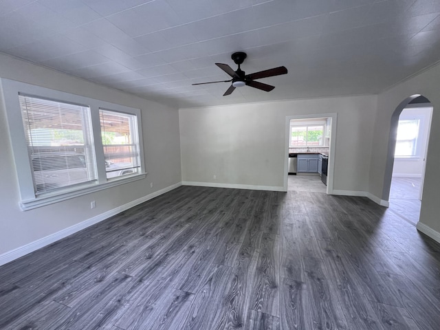 422 Wilderness Rd, Middlesboro, KY 40965 - empty room featuring arched walkways, a ceiling fan, dark wood-style floors, and baseboards