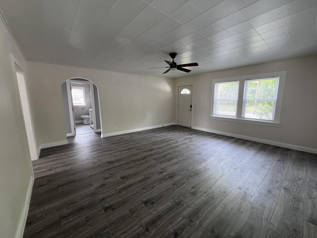 422 Wilderness Rd, Middlesboro, KY 40965 - unfurnished living room with arched walkways, plenty of natural light, a ceiling fan, and dark wood-type flooring