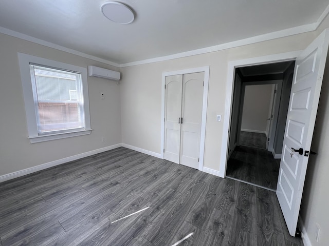 422 Wilderness Rd, Middlesboro, KY 40965 - unfurnished bedroom with an AC wall unit, dark wood finished floors, baseboards, and a closet
