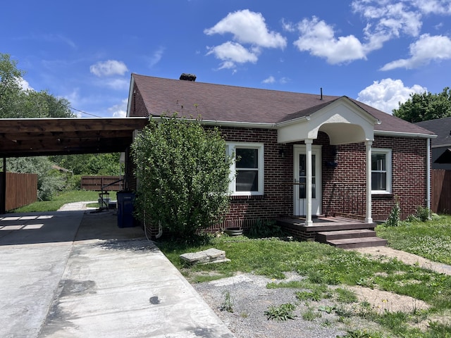422 Wilderness Rd, Middlesboro, KY 40965 - bungalow-style house featuring brick siding, driveway, a shingled roof, an attached carport, and fence